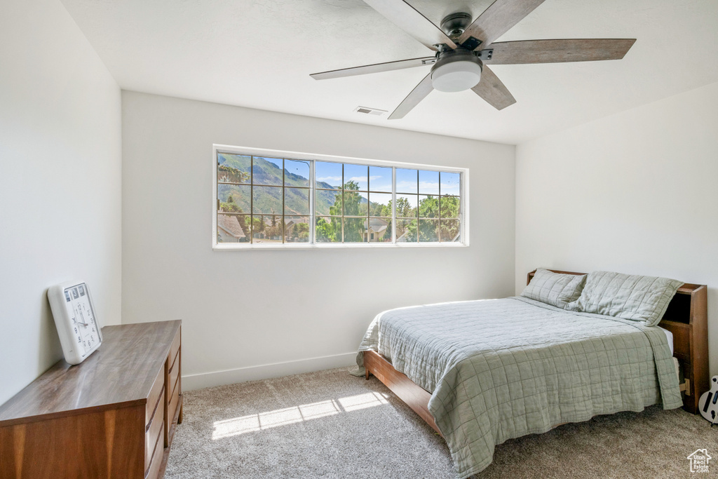 Bedroom featuring carpet floors, baseboards, and ceiling fan