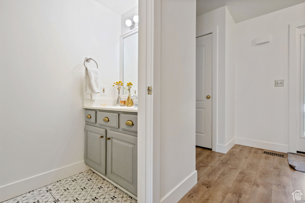 Bathroom with vanity, baseboards, and wood finished floors