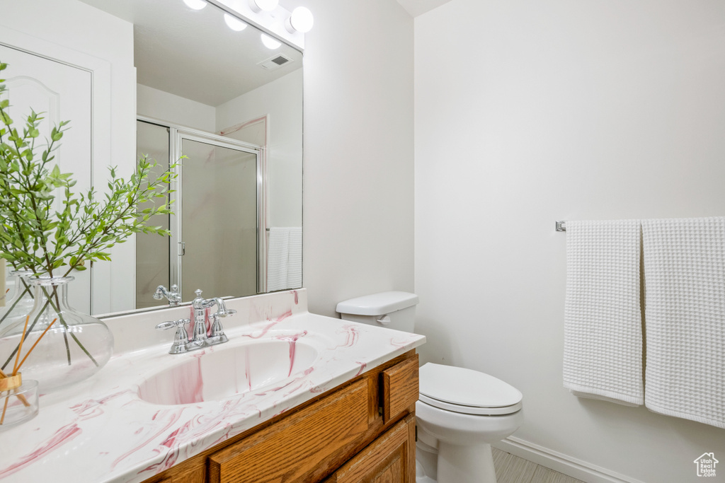 Full bathroom with vanity, toilet, and a shower with door