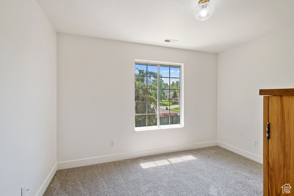 Carpeted spare room with baseboards