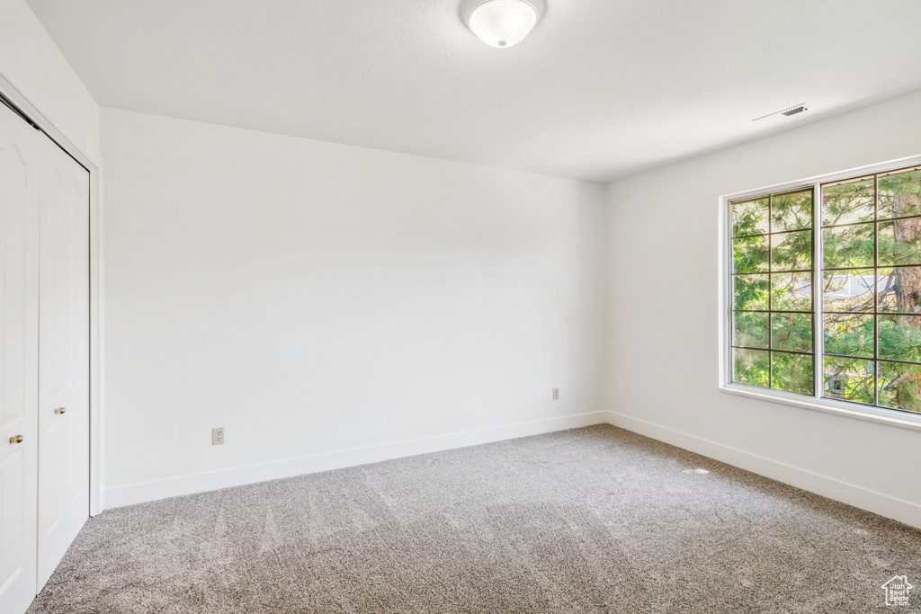 Spare room with carpet and baseboards