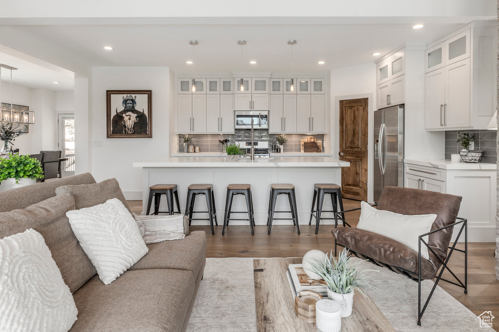 Living room featuring recessed lighting, dark wood-style flooring, and a chandelier