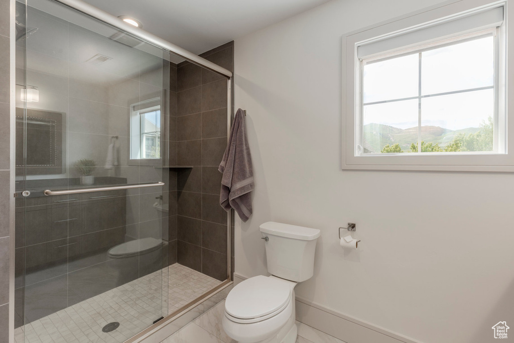 Full bath with toilet, a stall shower, and baseboards