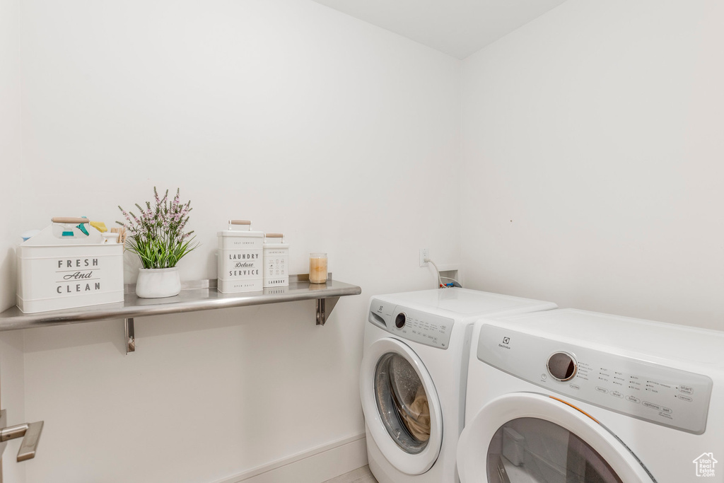 Washroom featuring washer and dryer and baseboards