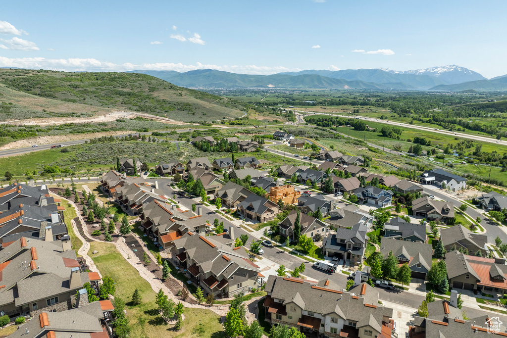 Aerial view of property and surrounding area with nearby suburban area and a mountain backdrop