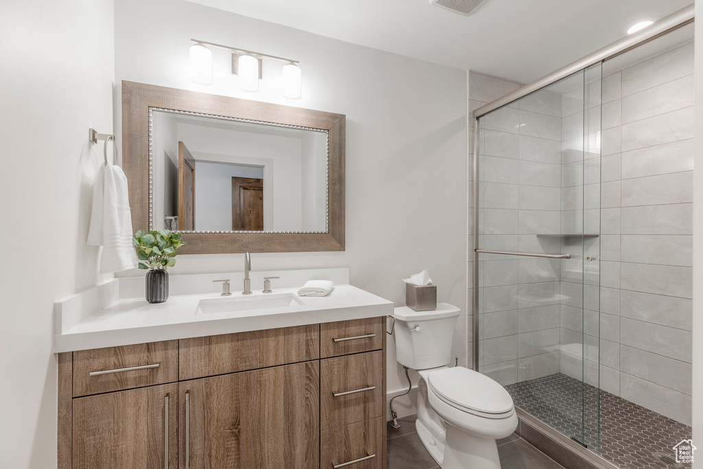 Full bath with toilet, vanity, and a stall shower