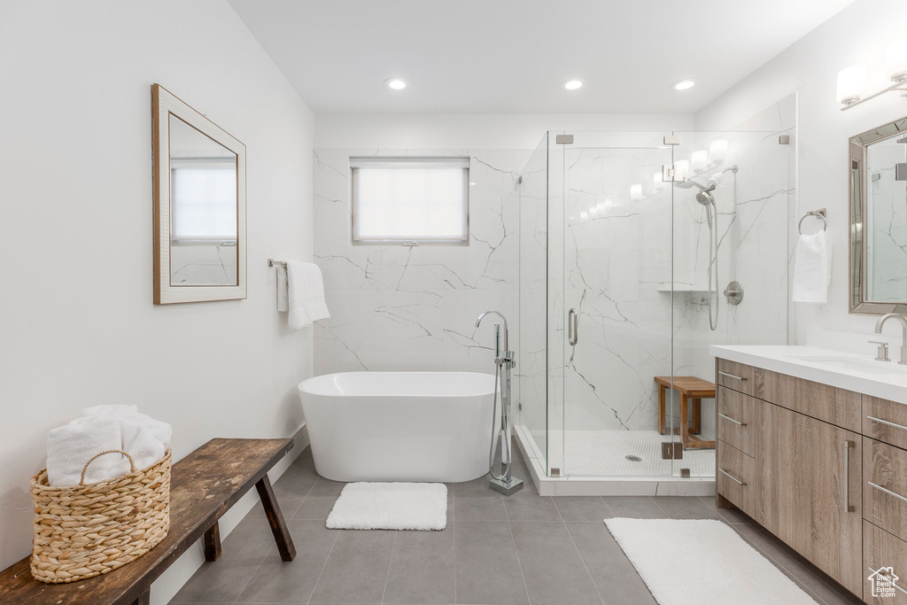 Bathroom with a freestanding tub, a marble finish shower, vanity, tile patterned floors, and recessed lighting