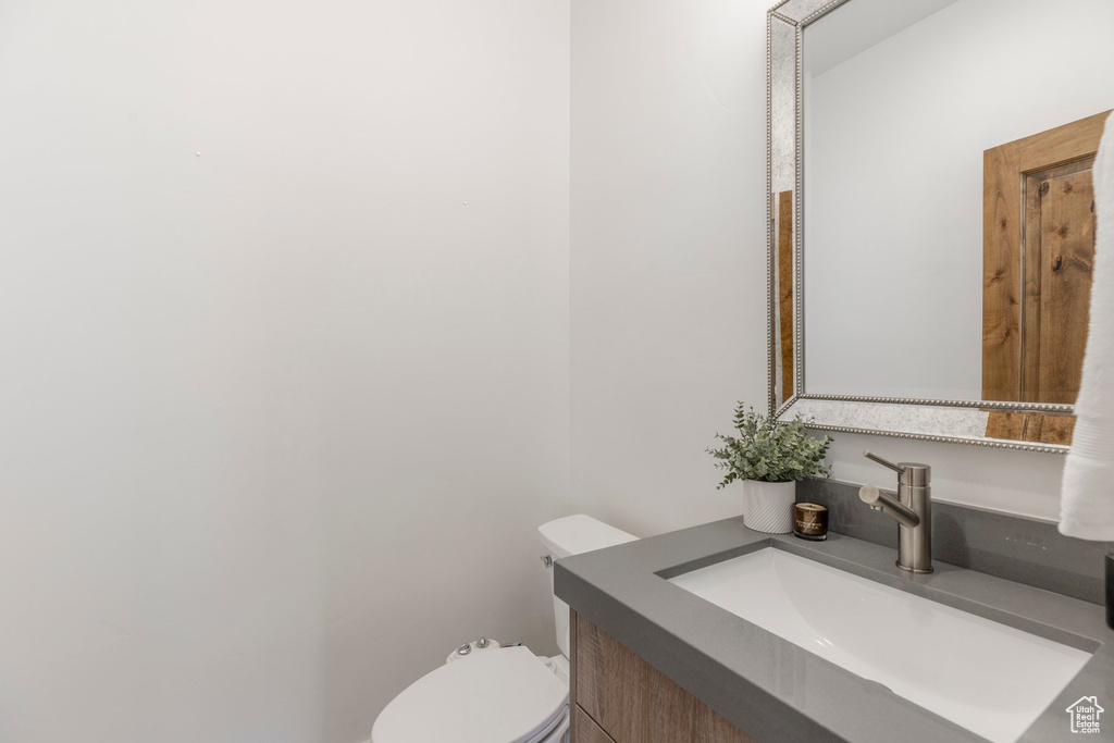 Half bathroom featuring vanity and toilet