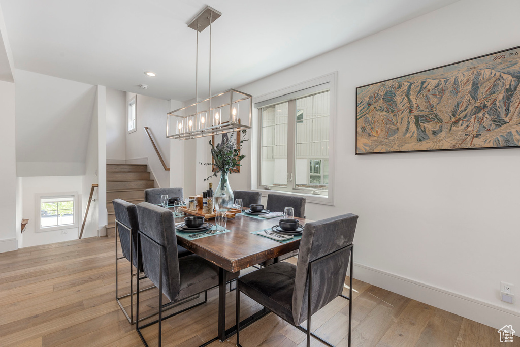 Dining room with light wood-style floors, stairs, recessed lighting, baseboards, and a chandelier