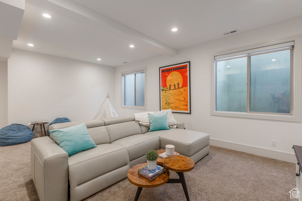 Carpeted living area with recessed lighting, baseboards, and beamed ceiling
