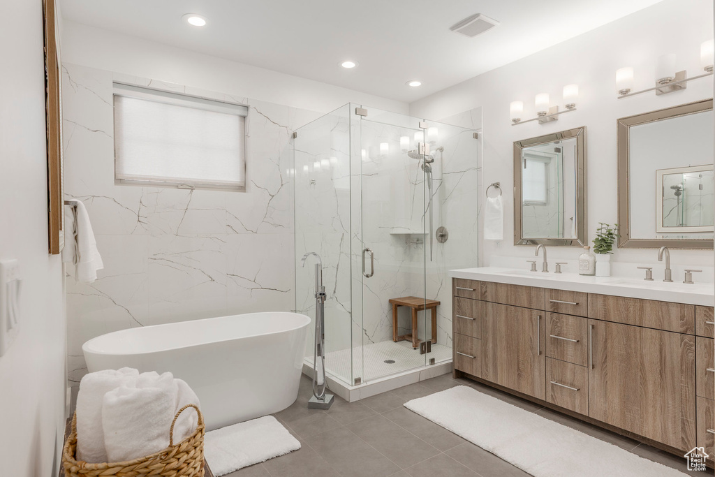 Bathroom with double vanity, a soaking tub, a marble finish shower, tile patterned floors, and recessed lighting