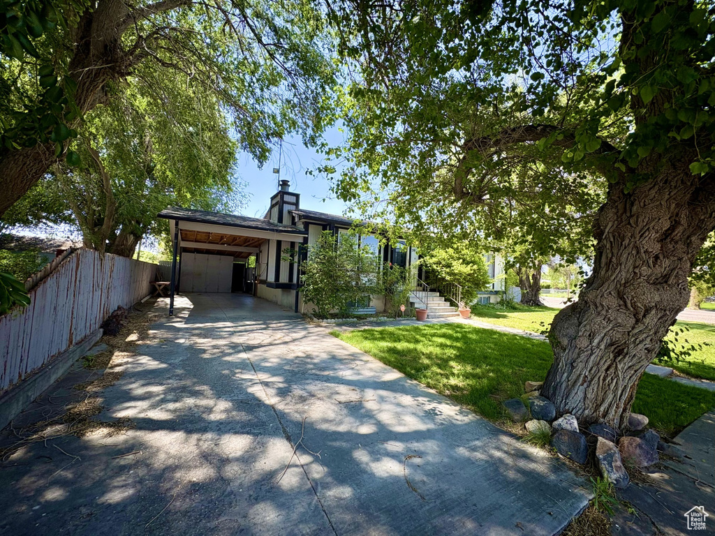 View of front of property featuring concrete driveway and a chimney