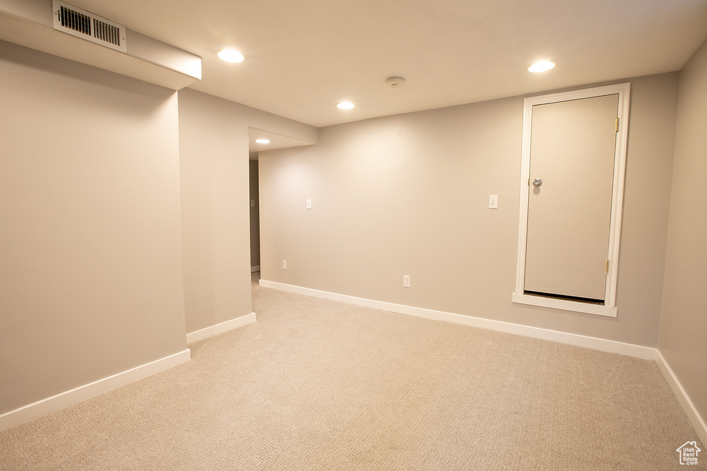 Finished below grade area featuring light carpet, recessed lighting, and baseboards