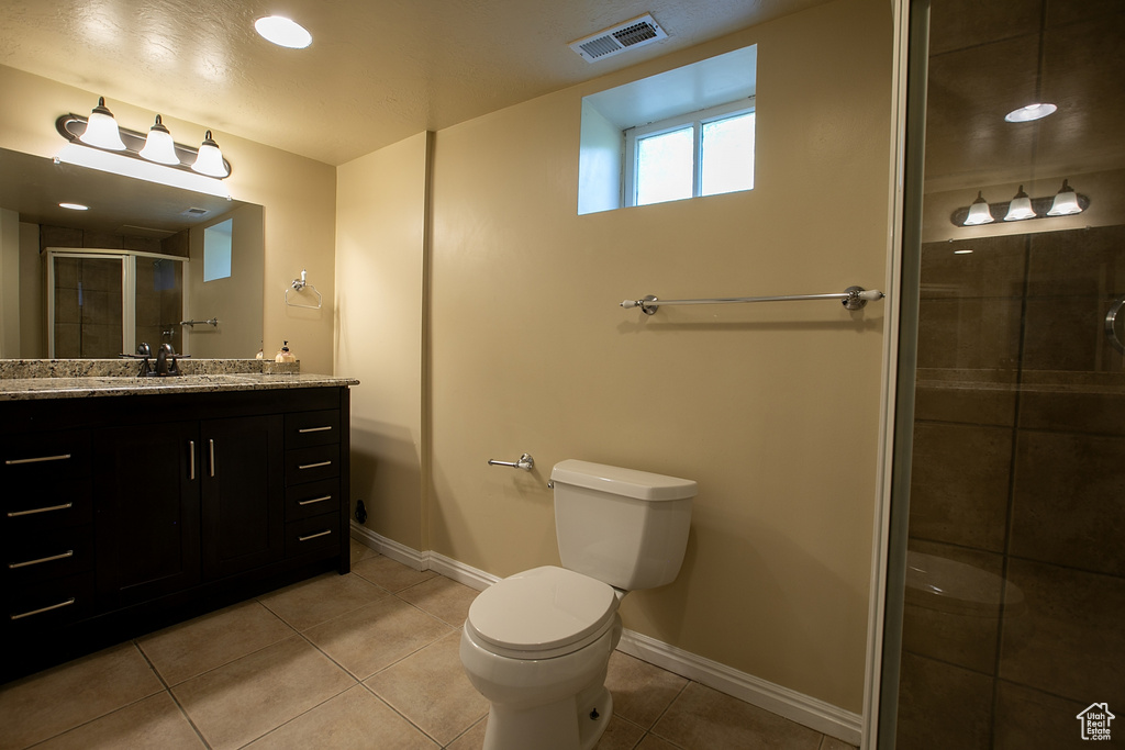 Full bath featuring vanity, toilet, a shower stall, tile patterned flooring, and baseboards