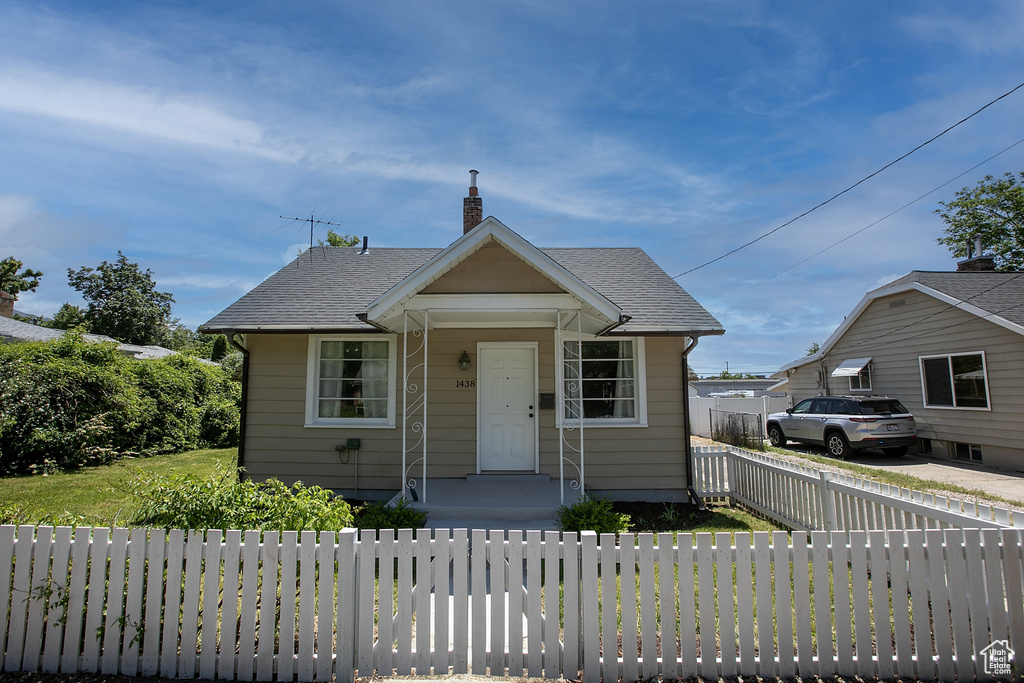 Bungalow-style house with a chimney and roof with shingles