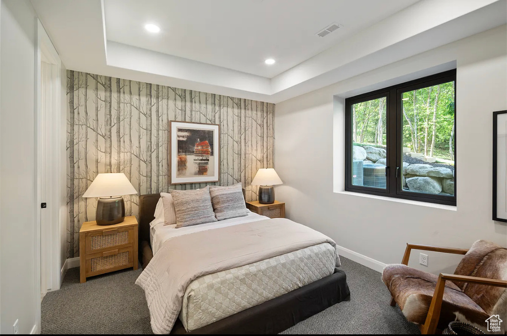 Carpeted bedroom with baseboards, recessed lighting, an accent wall, and a tray ceiling