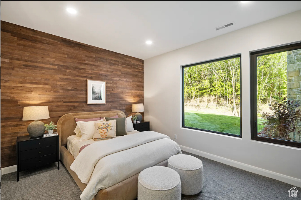 Bedroom with wooden walls, multiple windows, baseboards, recessed lighting, and carpet flooring