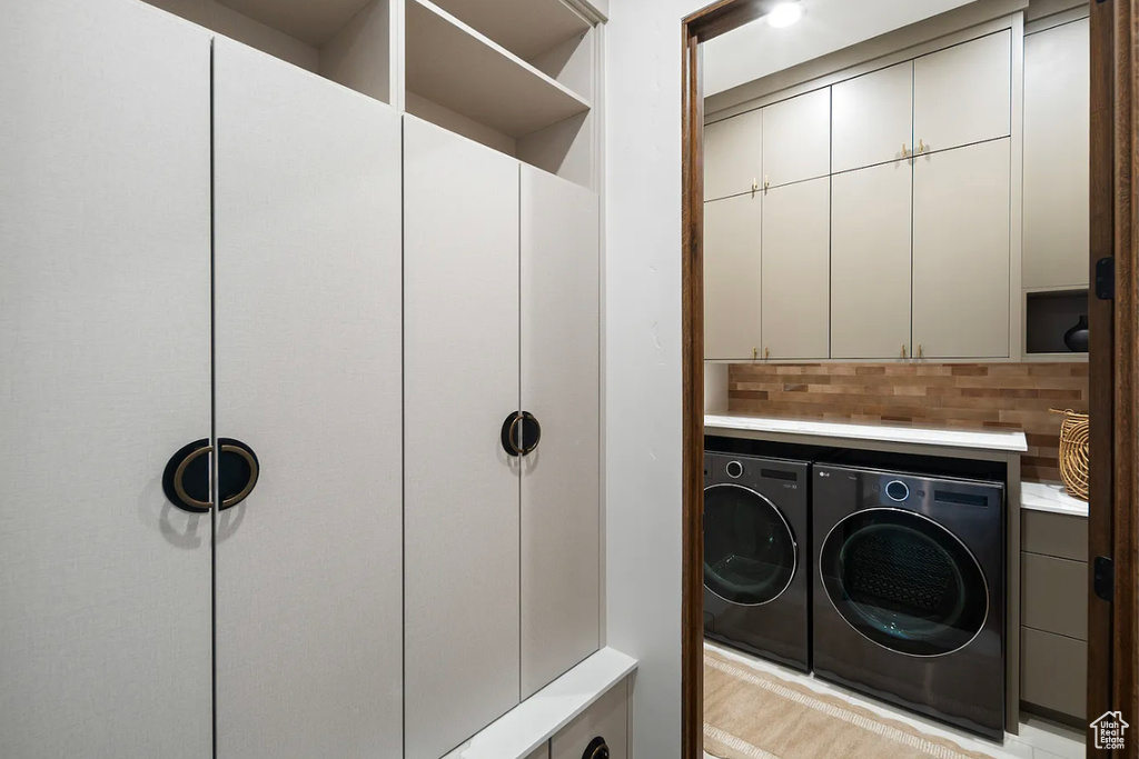 Laundry area featuring washing machine and clothes dryer and cabinet space