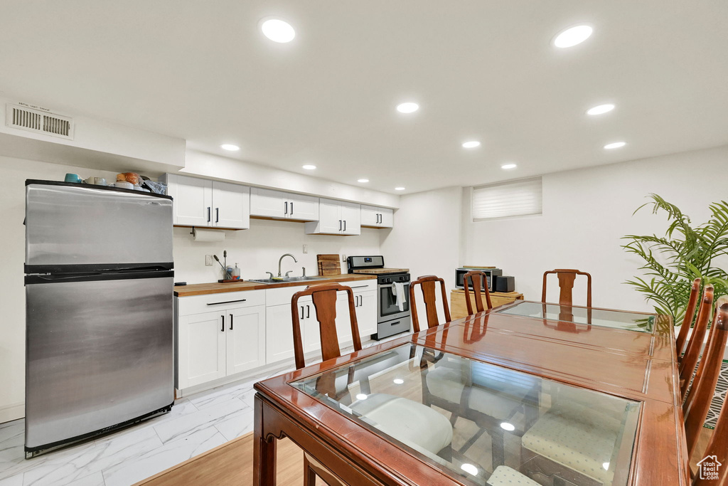Dining space with recessed lighting and light marble finish floors