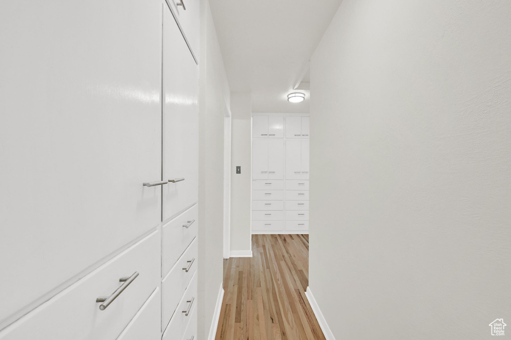 Hallway with light wood-type flooring and baseboards