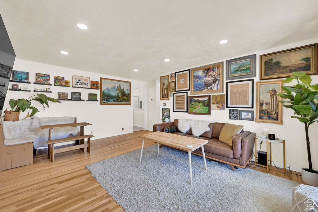 Living room with light wood-style flooring and recessed lighting