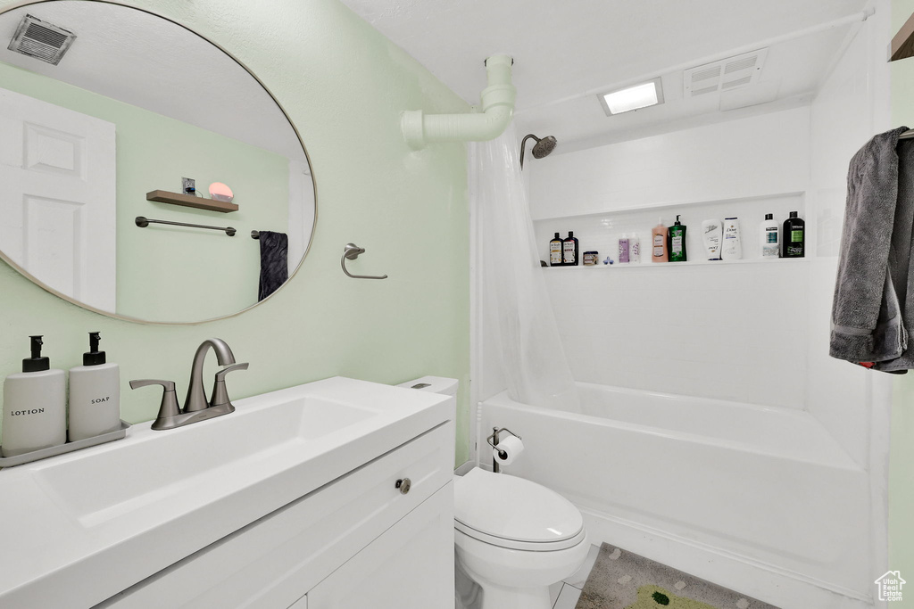 Full bathroom with toilet, vanity, and shower / tub combo with curtain