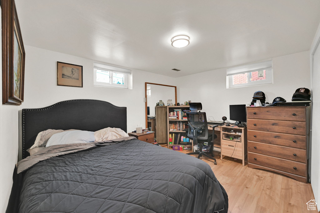 Bedroom featuring light wood-type flooring and an office area
