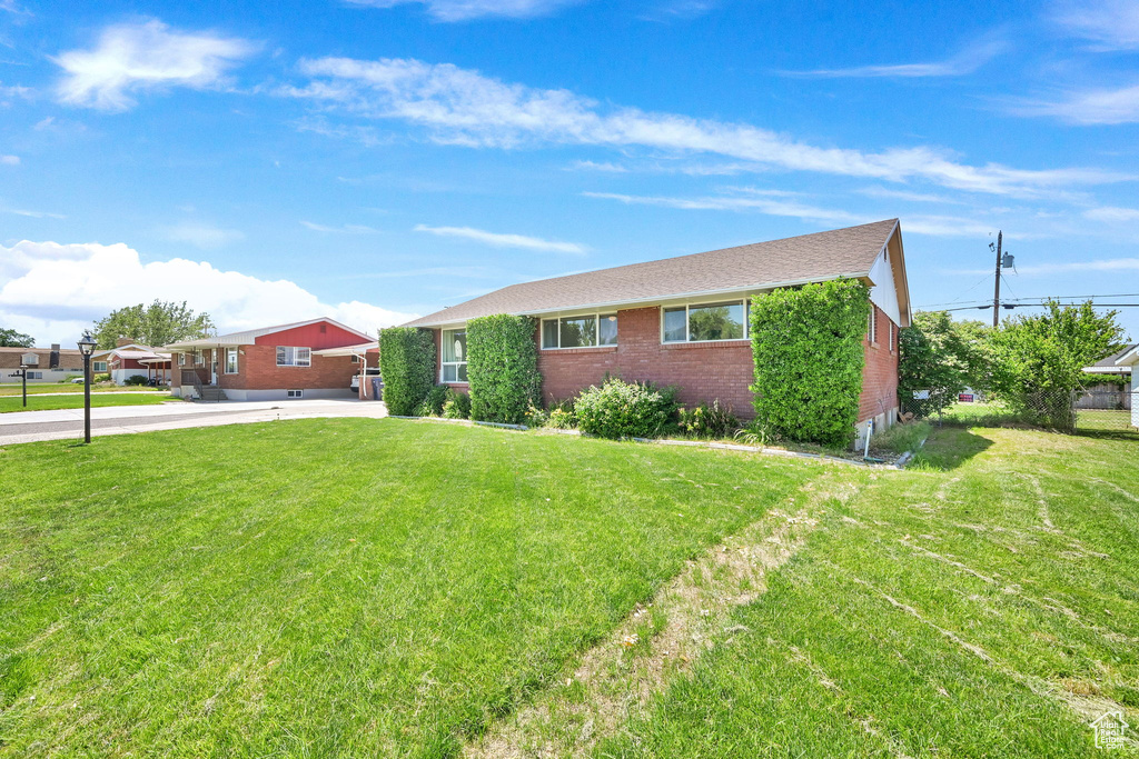 Ranch-style home with brick siding, a front yard, and driveway