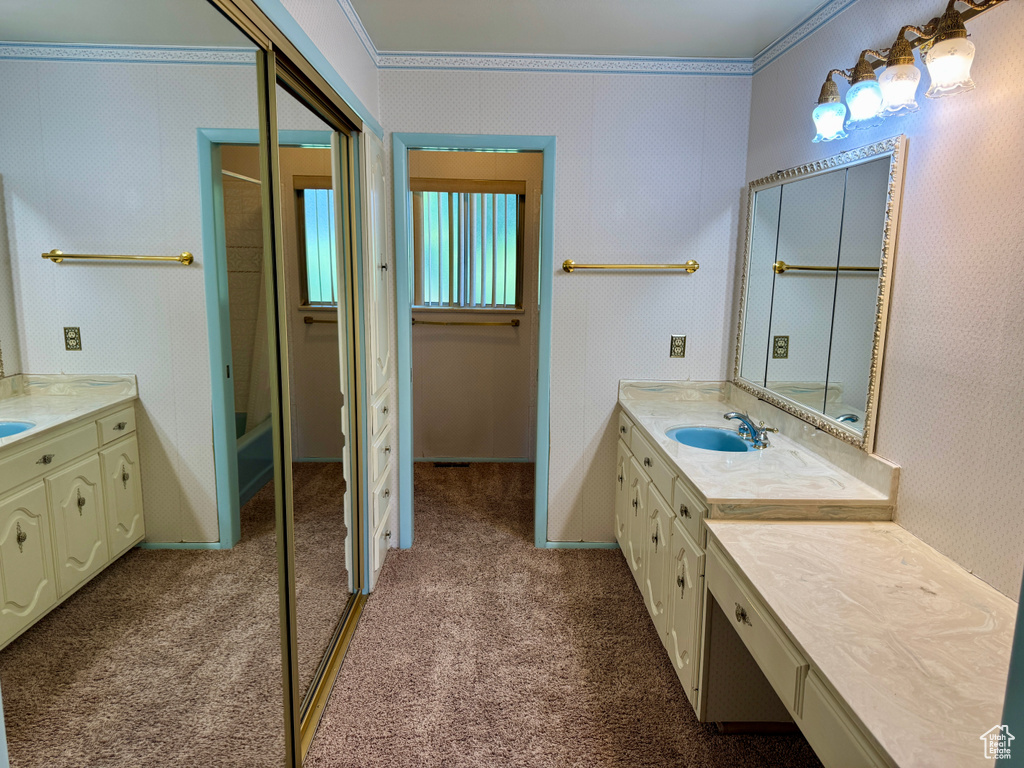 Full bath featuring vanity, crown molding, and bathtub / shower combination