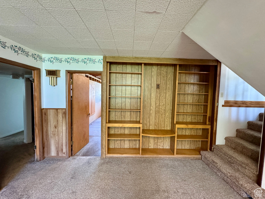Unfurnished bedroom with carpet and wooden walls