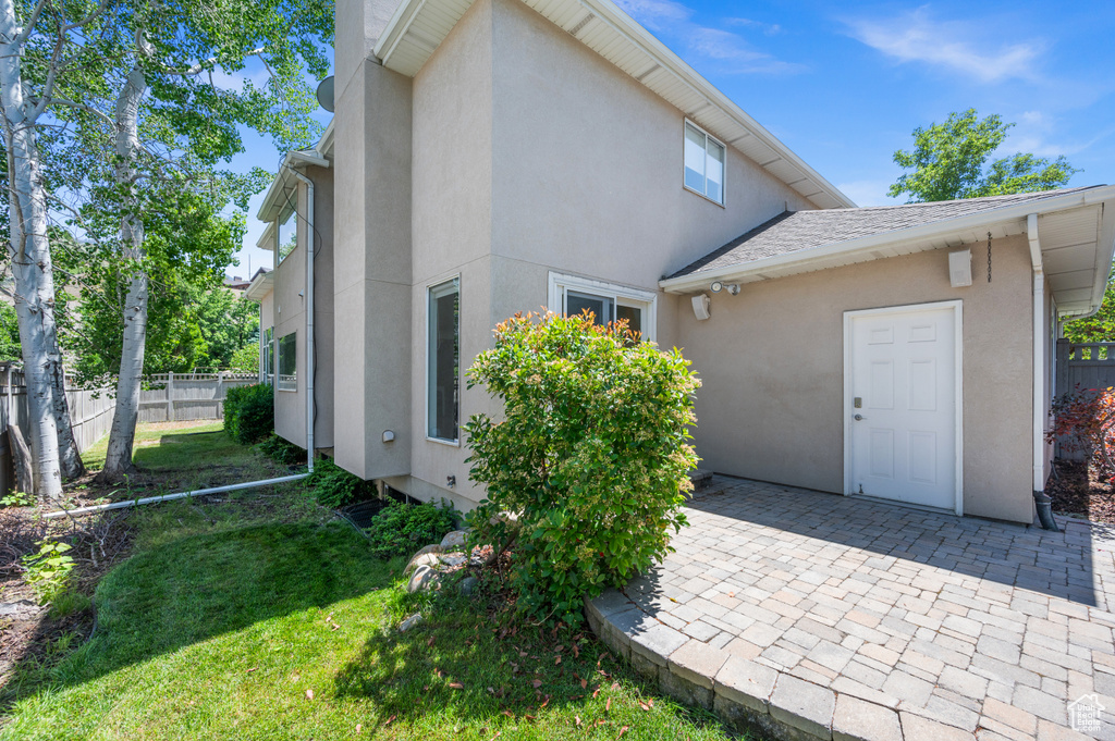View of property exterior with stucco siding and a patio area