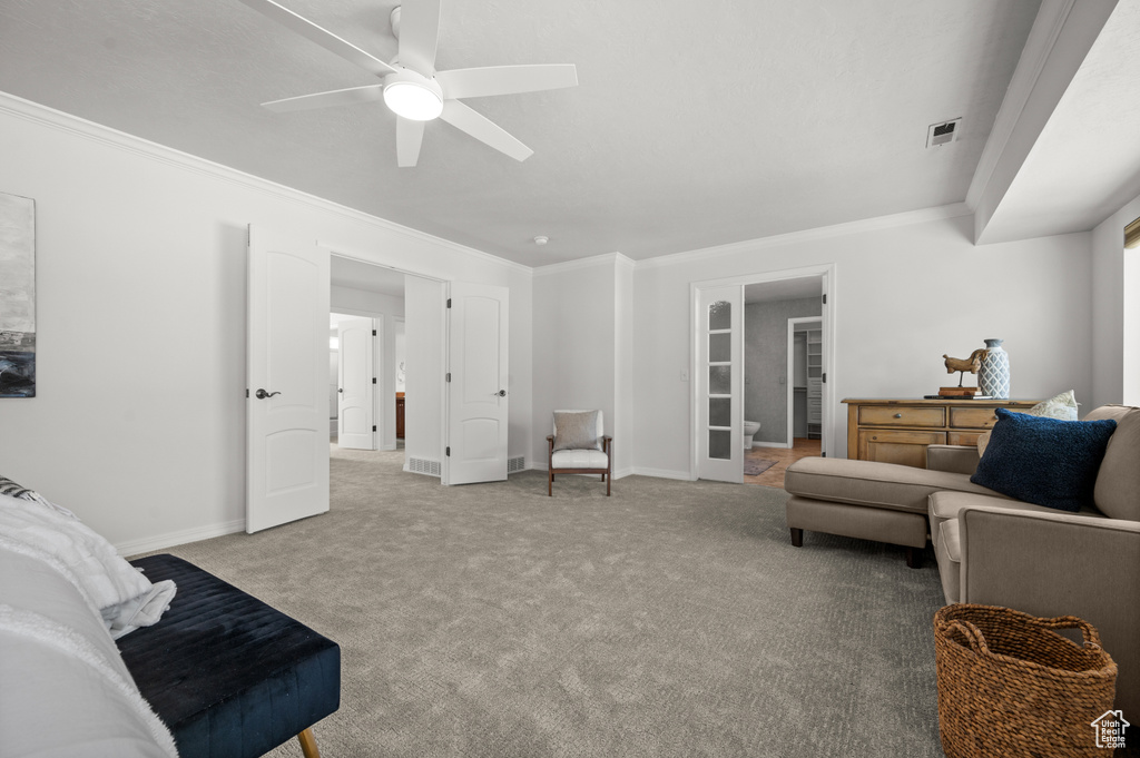 Living room featuring ornamental molding, a ceiling fan, carpet flooring, and baseboards