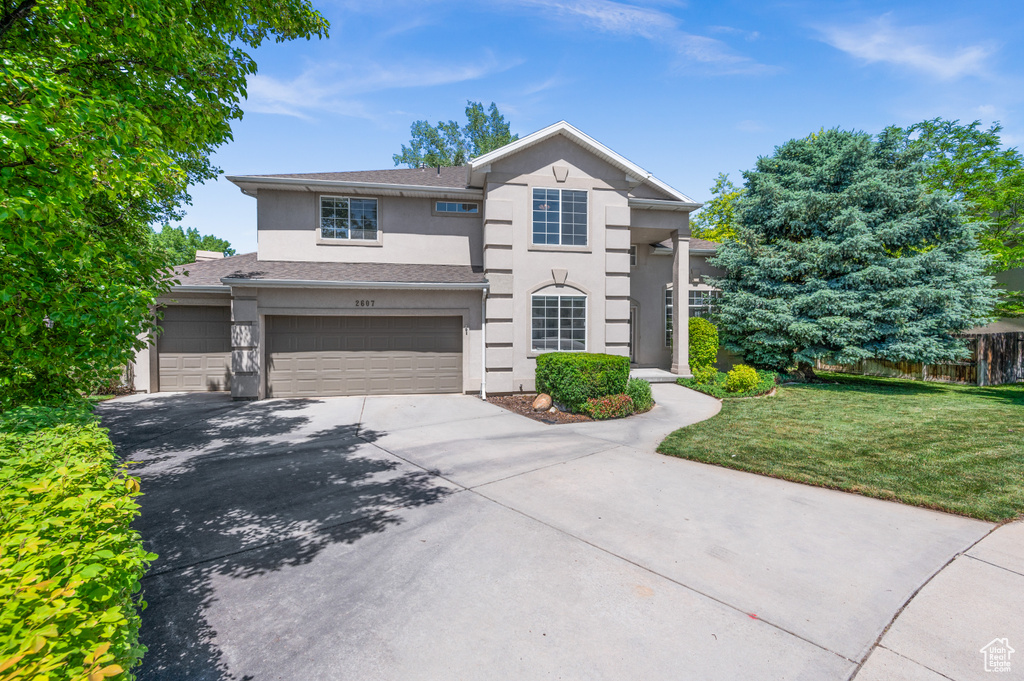 View of front of house featuring stucco siding, concrete driveway, and an attached garage