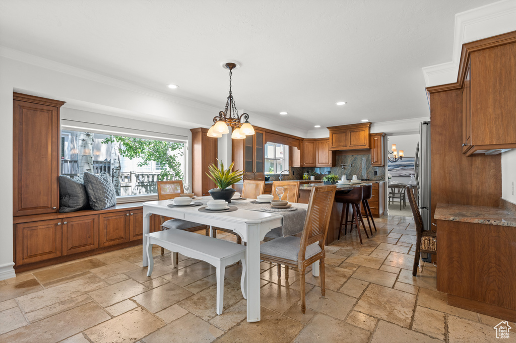 Dining room featuring stone tile flooring, recessed lighting, a chandelier, and ornamental molding