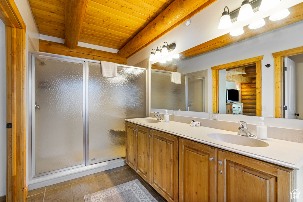 Full bathroom featuring double vanity, a shower stall, tile patterned flooring, and wood ceiling with exposed beams