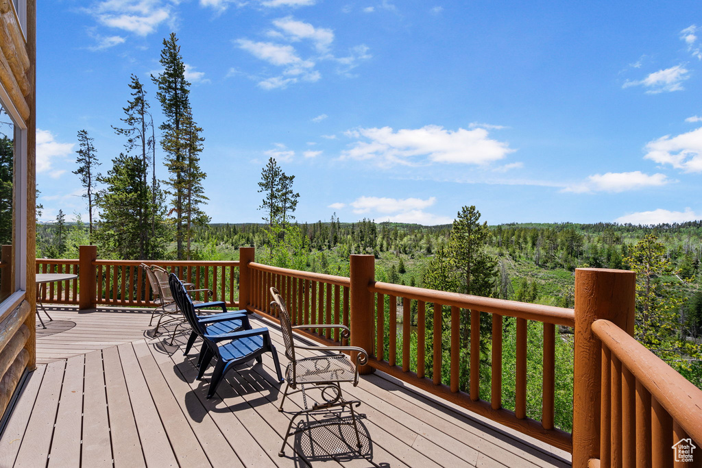 Wooden terrace featuring a view of trees