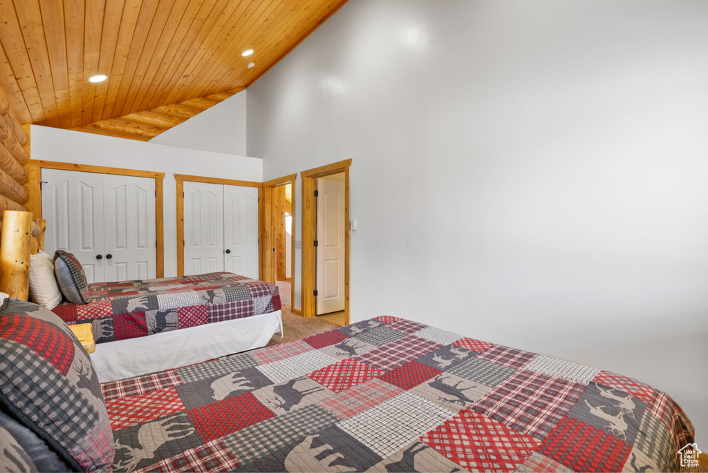 Carpeted bedroom featuring recessed lighting, wooden ceiling, multiple closets, and lofted ceiling