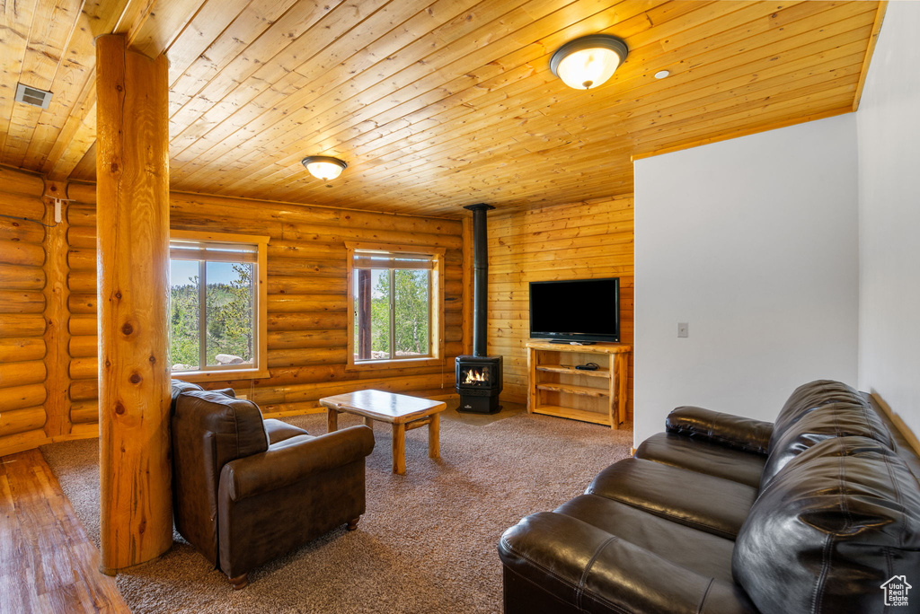 Living room featuring a wood stove, wooden ceiling, and rustic walls