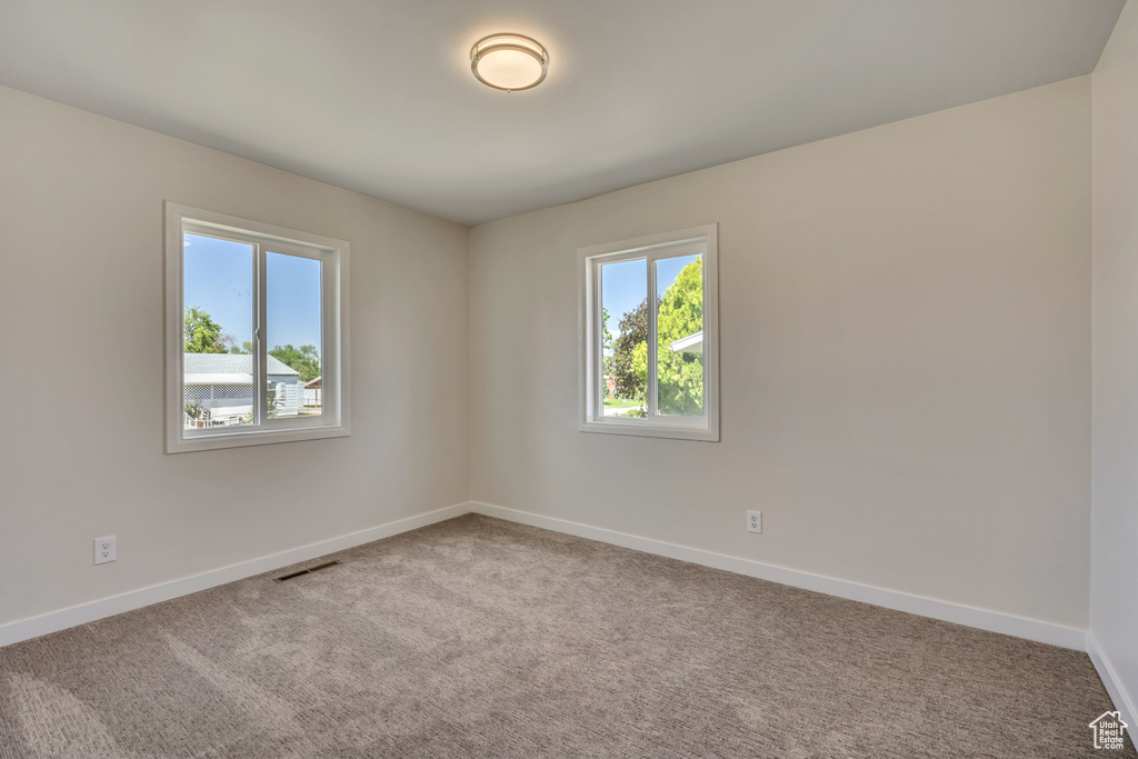 Carpeted spare room with baseboards