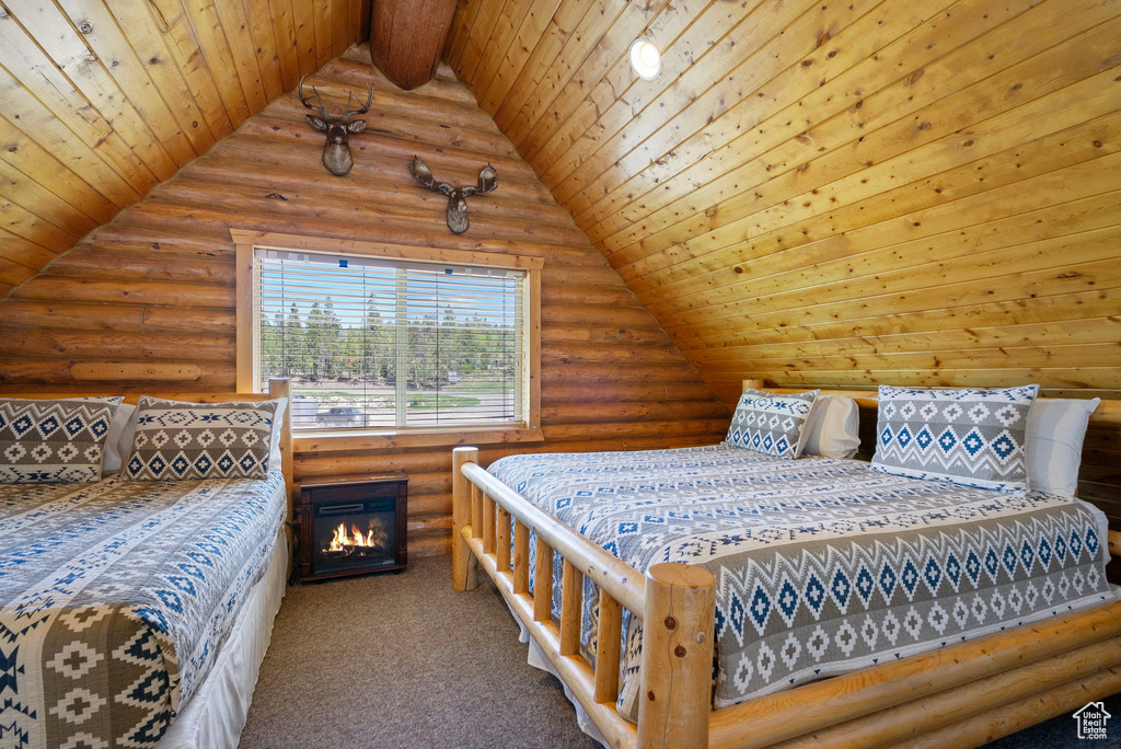 Carpeted bedroom with rustic walls, wooden ceiling, and vaulted ceiling