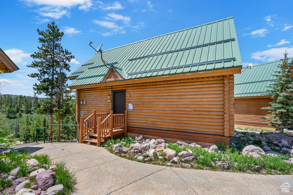 Log-style house with log siding, metal roof, and a standing seam roof