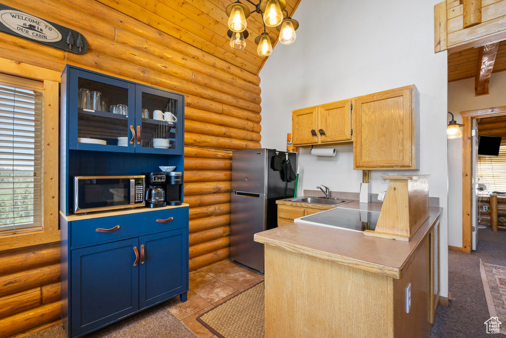 Kitchen with rustic walls, stainless steel appliances, high vaulted ceiling, a sink, and glass insert cabinets
