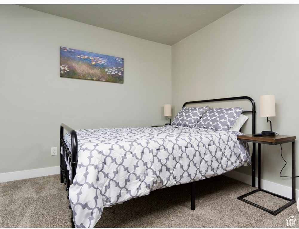 Bedroom featuring carpet and baseboards