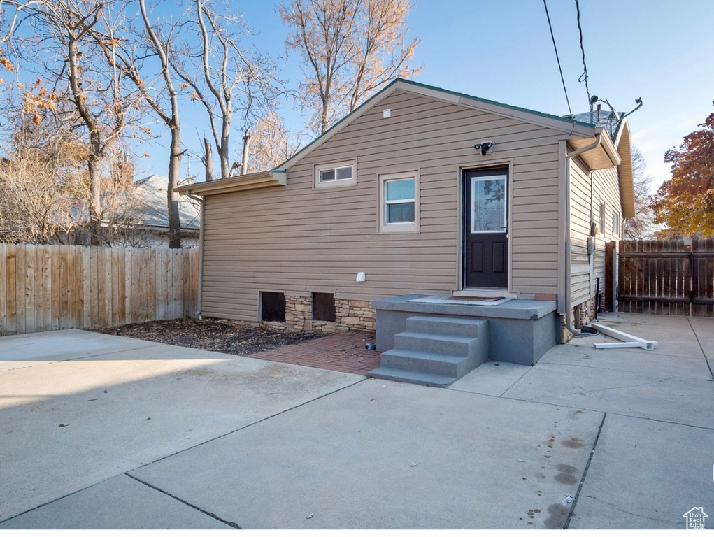 Rear view of property with a fenced backyard and a patio area