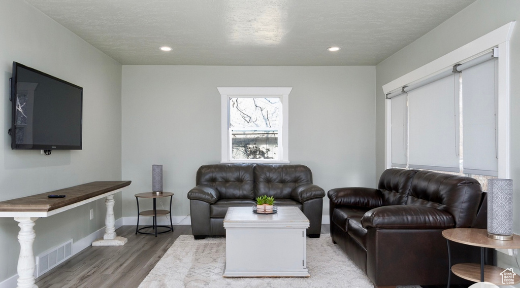 Living room featuring light wood-style floors, baseboards, and recessed lighting