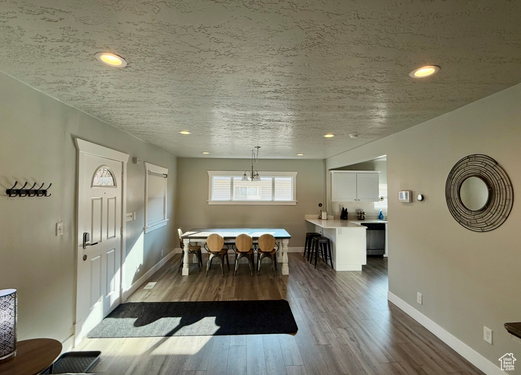 Dining room featuring dark wood-type flooring, baseboards, and recessed lighting