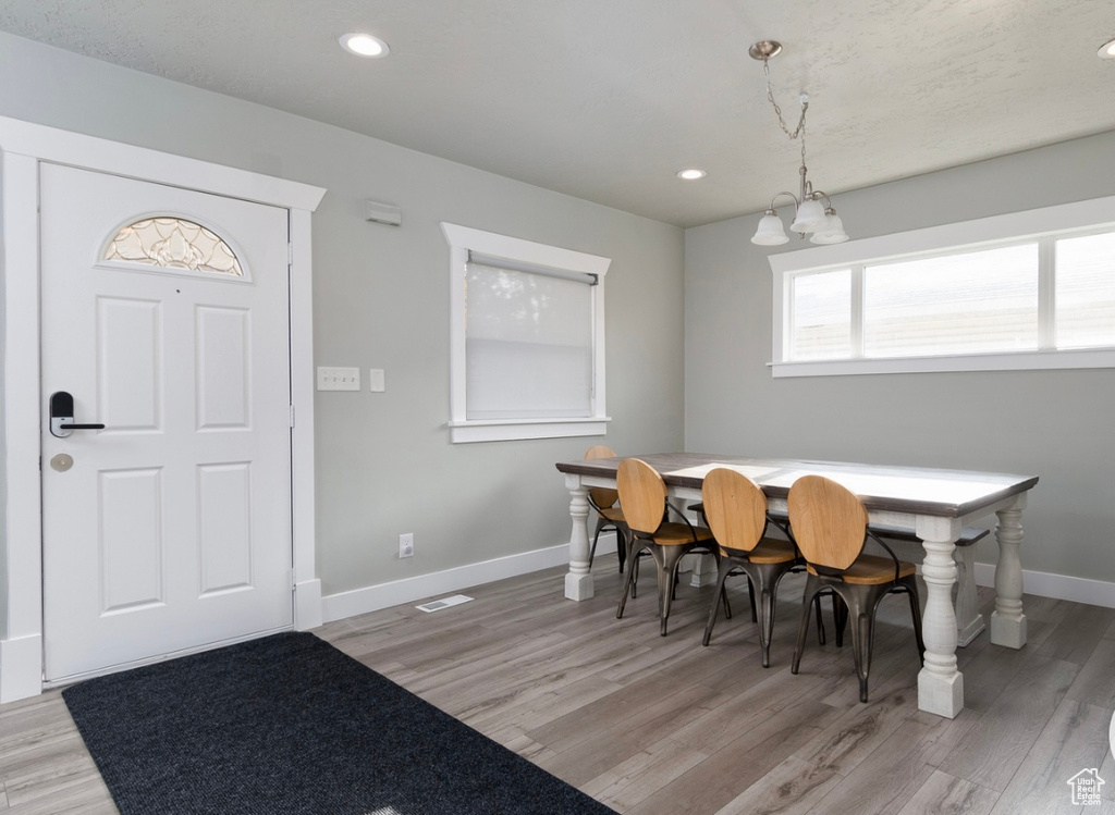 Dining space with baseboards, a chandelier, light wood-style floors, and recessed lighting