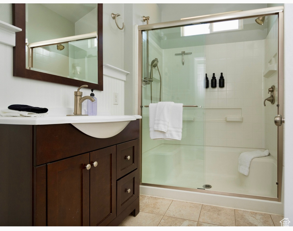 Bathroom featuring a shower stall, vanity, and tile patterned flooring