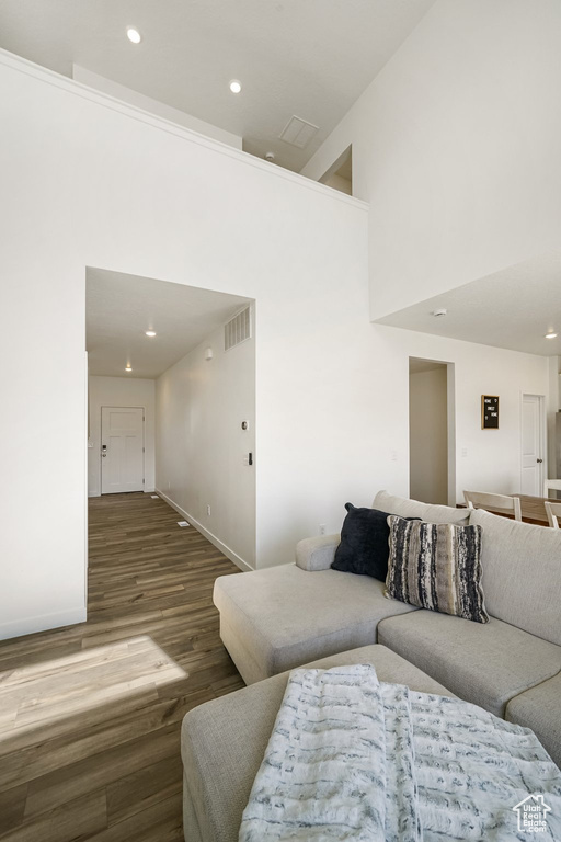 Living room with wood finished floors, baseboards, and recessed lighting