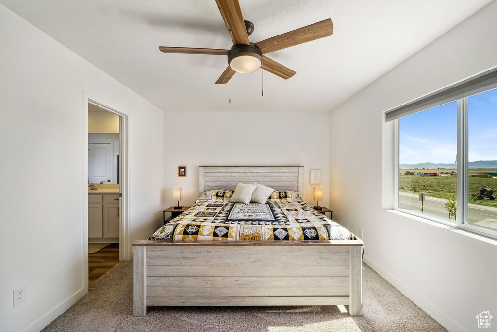 Carpeted bedroom featuring baseboards and a ceiling fan